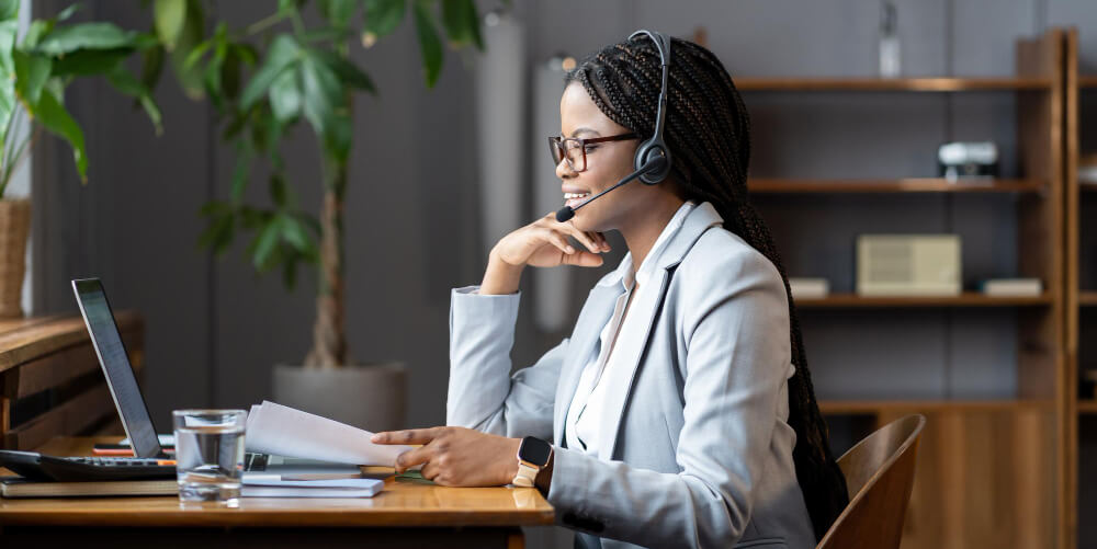 young positive african woman remote recruiter using wireless headset communicate with candidates